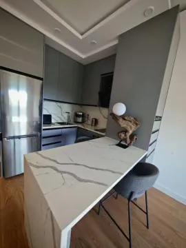 Moderna kuhinja sa šankom, trpezarijskim stolom i ugradnim elementima. - image 11