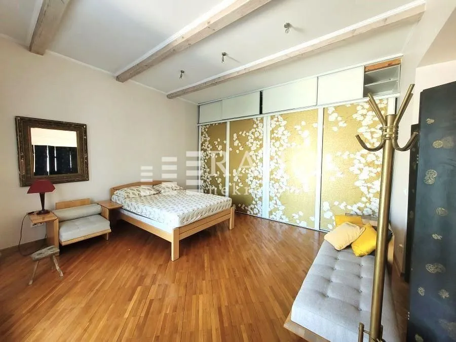 Spacious bedroom with a double bed, wooden flooring, and a large built-in wardrobe.