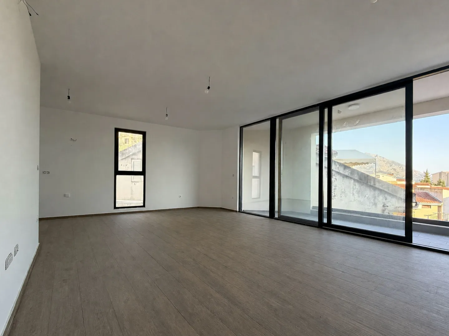 Empty room with large glass surfaces and access to the terrace.