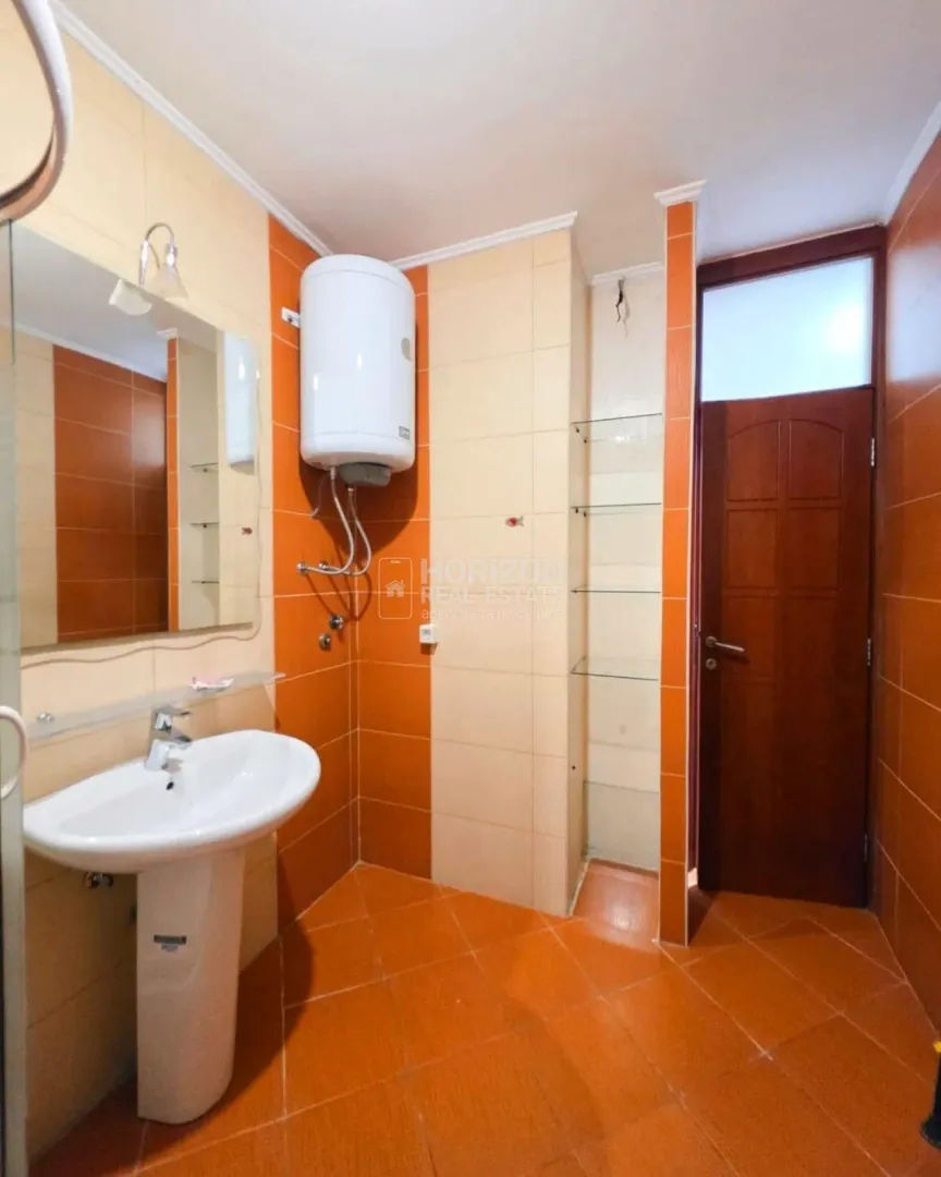 Small bathroom with a washbasin and tiles in orange tones.