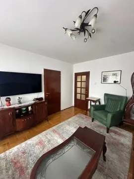 Dnevna soba sa garniturom, televizorom i drvenim namještajem. - image 2