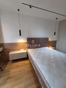 Moderna spavaća soba sa bračnim krevetom, drvenim panelima i visećim lampama. - image 7