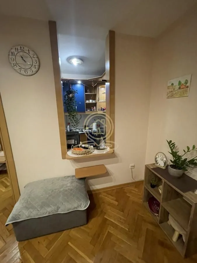 View from the living room towards the kitchen with a bar counter and wooden floor.