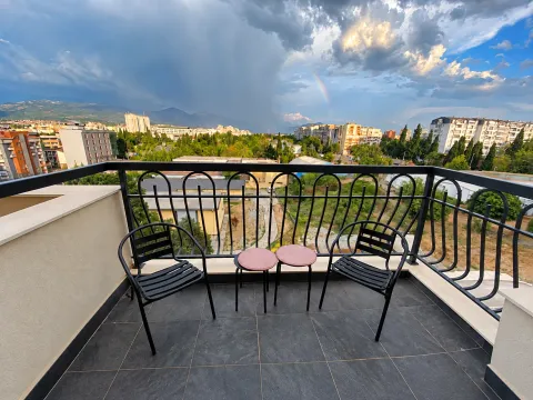 Balkon sa dvije stolice i pogledom na grad. - image 4