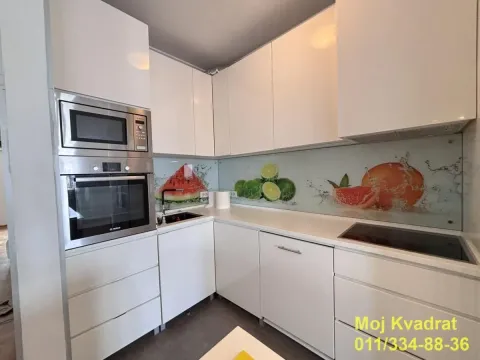 Moderna bela kuhinja sa ugrađenom rernom, mikrotalasnom i dekorativnom pozadinom sa motivom voća. - image 4