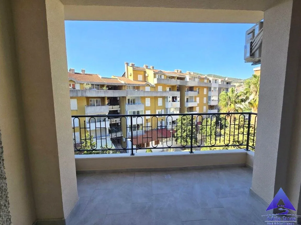 Natkriveni balkon sa pogledom na susjedne zgrade i okolinu.