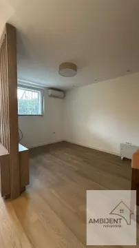Empty room with laminate flooring, white walls, and a wooden partition screen. - image 8