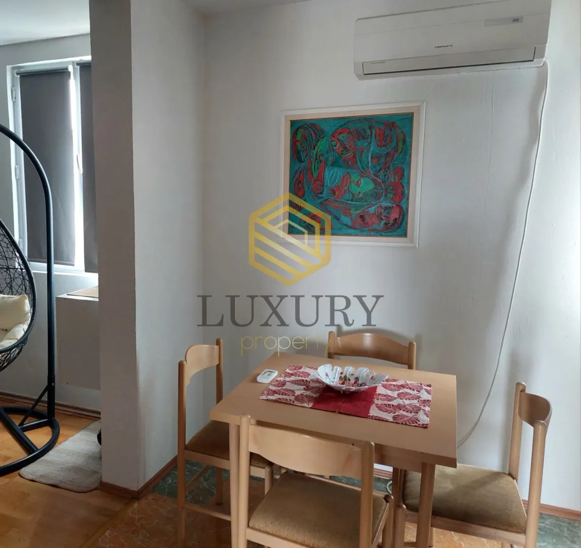 Small dining table with four chairs in a bright room.