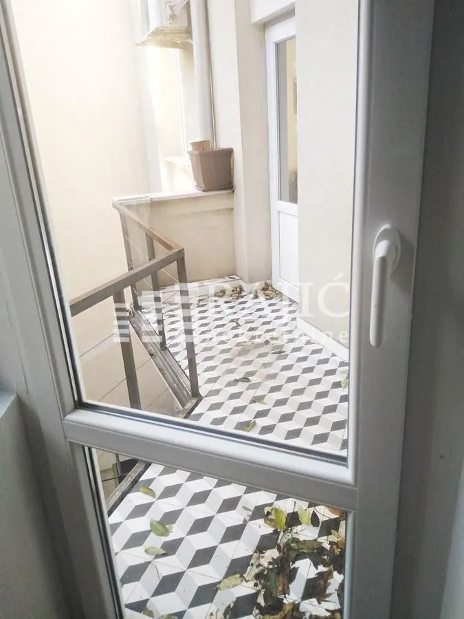 View through a window onto a tiled terrace.