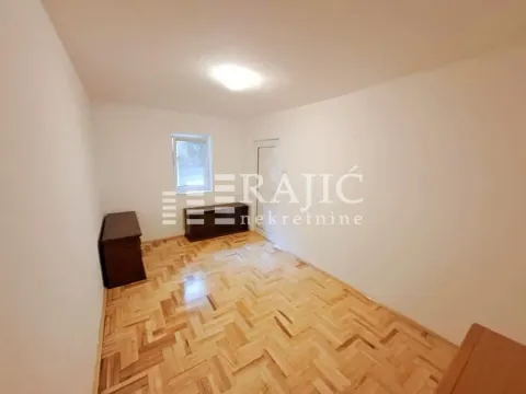 Empty room with parquet flooring and a window. - image 10