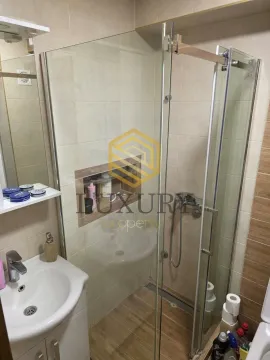 Small bathroom with a walk-in shower and washbasin. - image 4