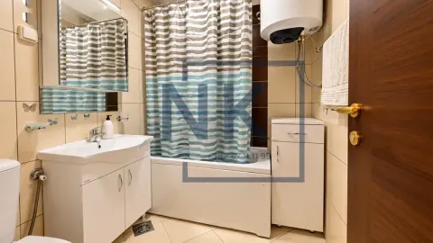 Bathroom equipped with a sink, a shower with a curtain, and a water heater. - image 15