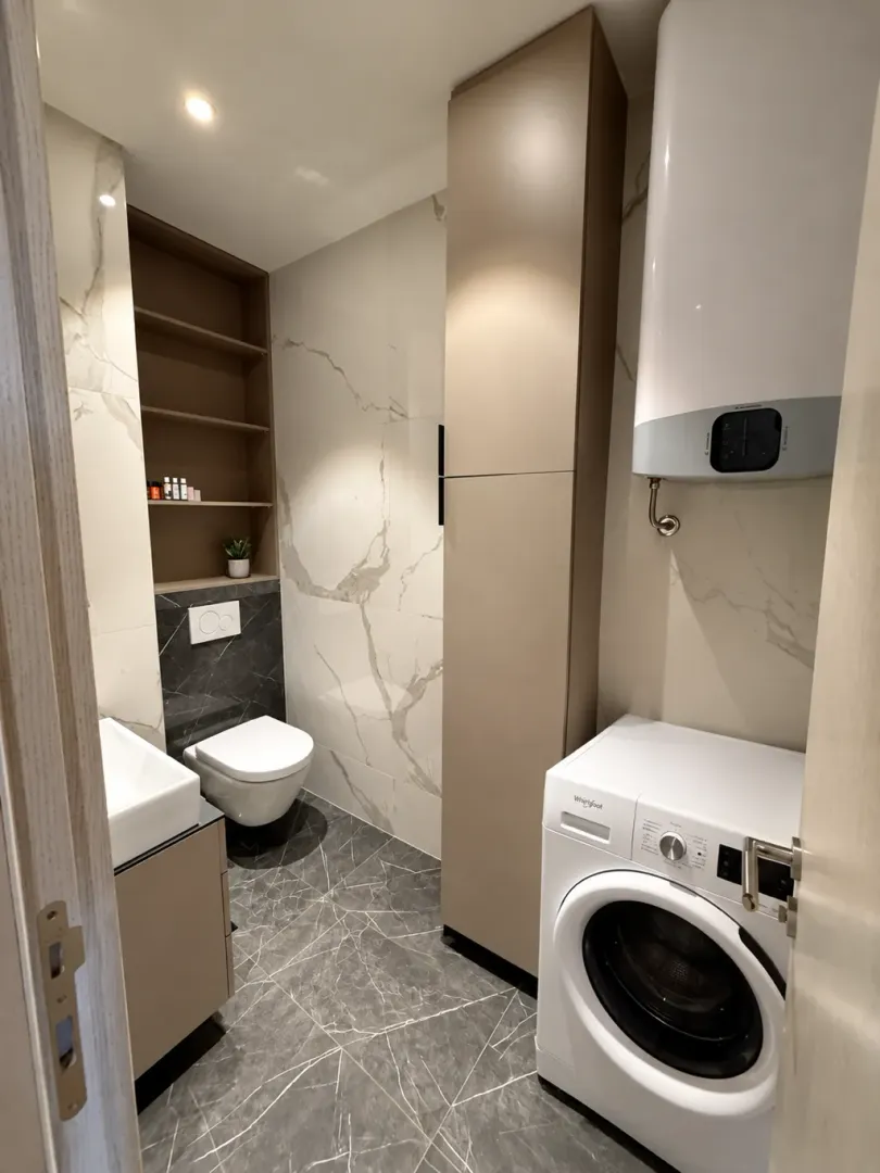 Moderno opremljeno kupatilo sa sanitarijama, tušem i veš mašinom.