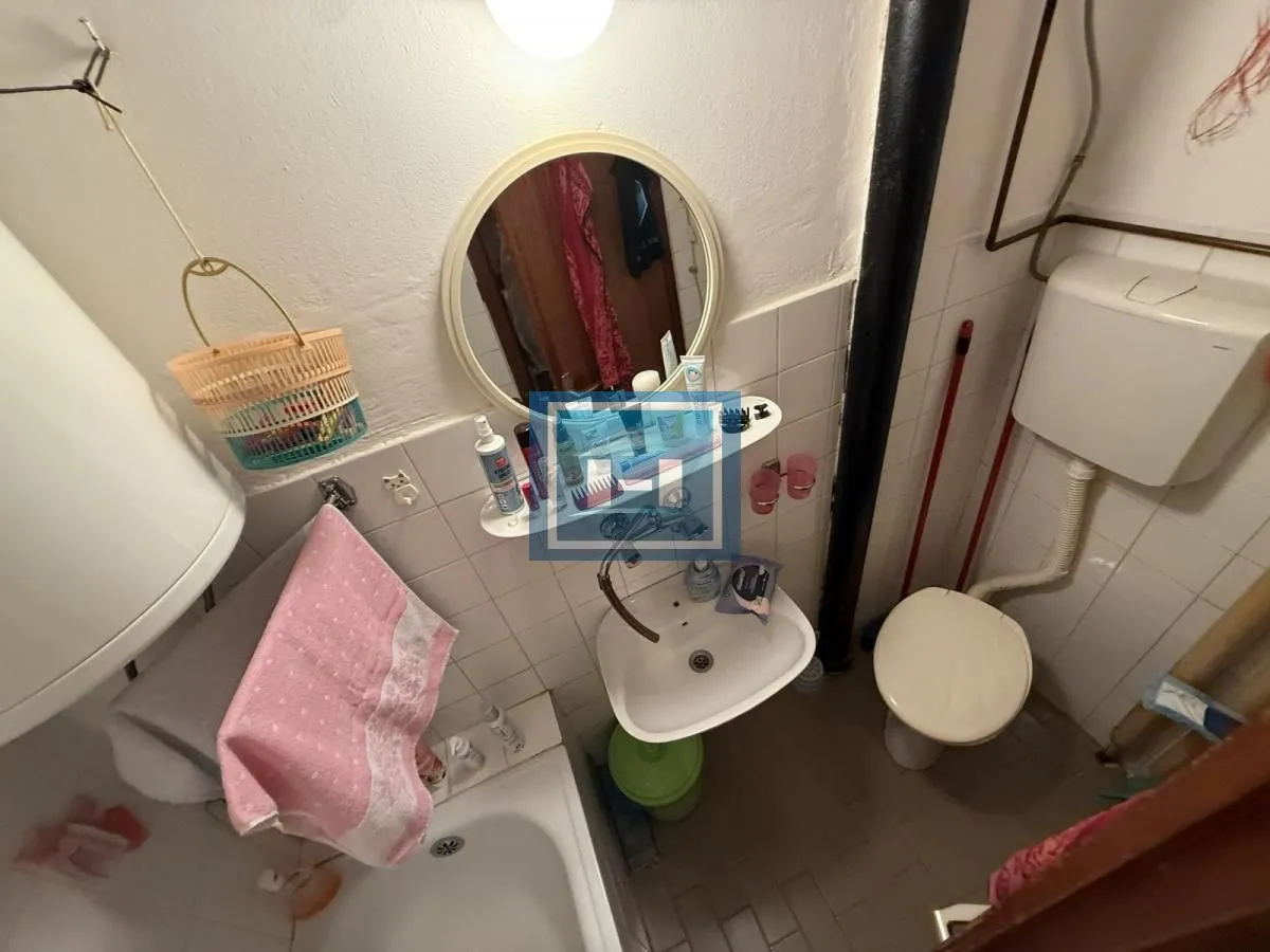 Smaller bathroom with a bathtub, washbasin, and toilet.