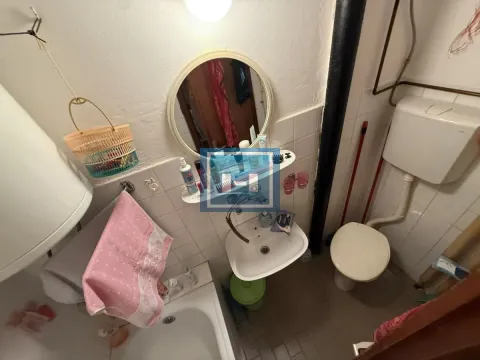Smaller bathroom with a bathtub, washbasin, and toilet. - image 6