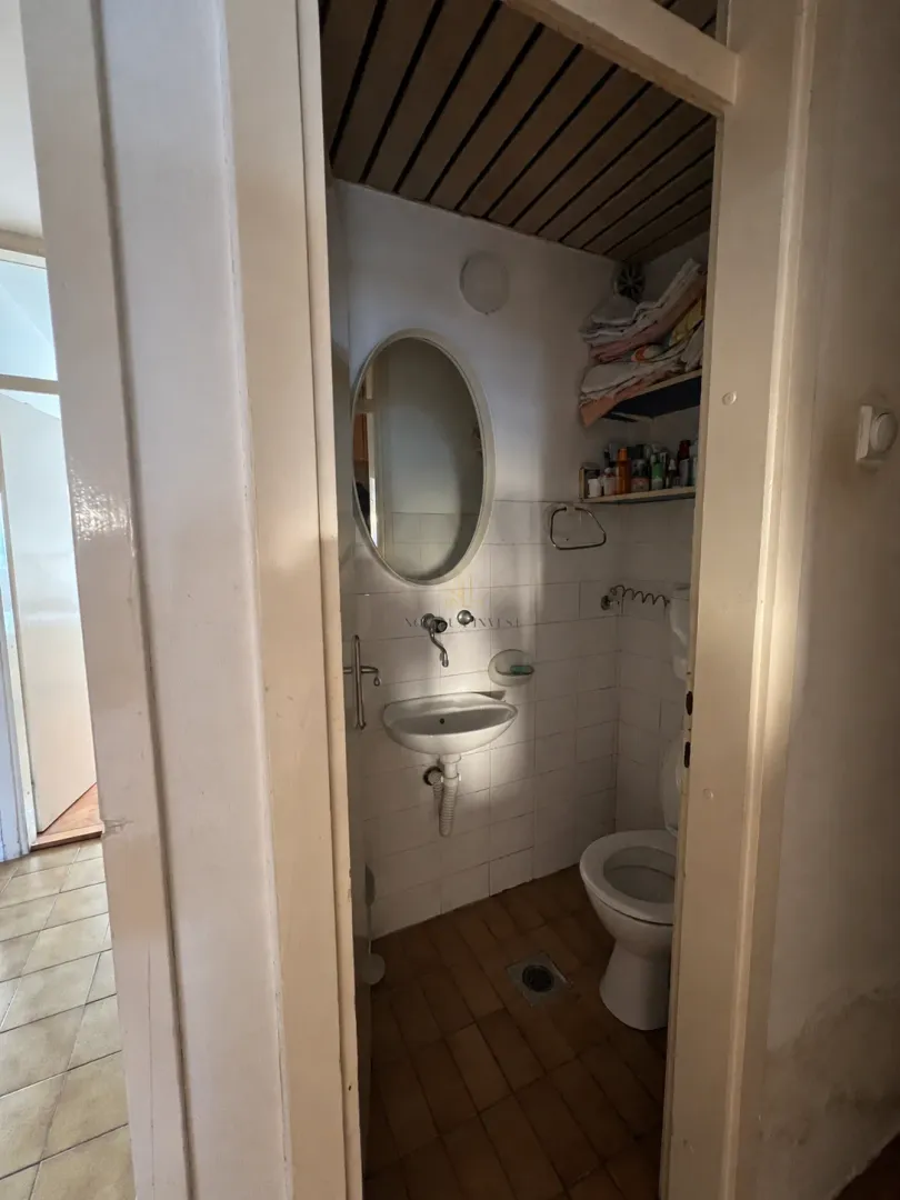 Manje kupatilo sa umivaonikom, ogledalom i toaletom.