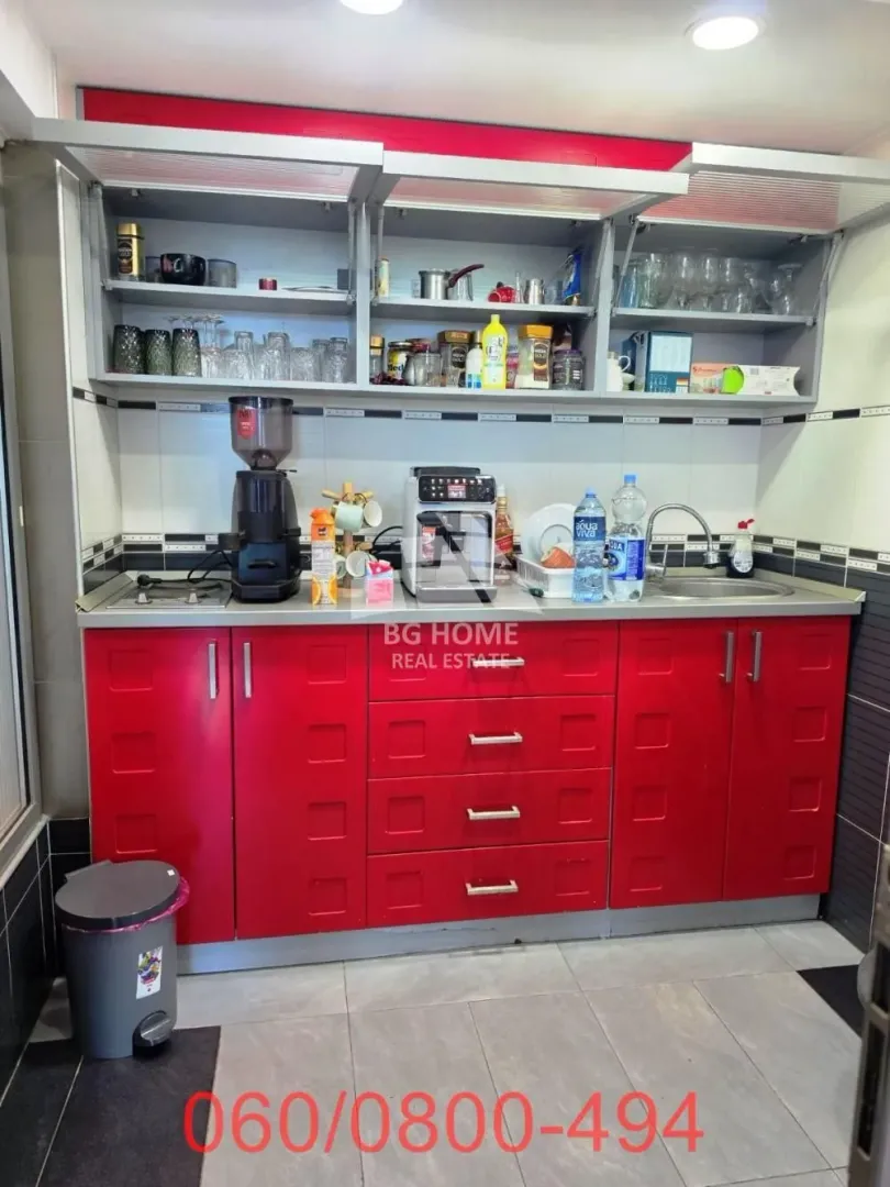 Kitchen with red cabinets, open shelving, and a sink.