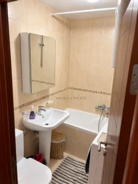 Bathroom equipped with a washbasin, bathtub, toilet, and washing machine. - image 7