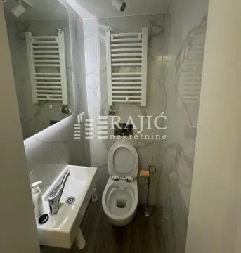 Modernly equipped bathroom with a washbasin and toilet. - image 9