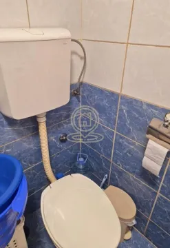 Pogled na kupatilo sa WC šoljom i pločicama na zidu. - image 16