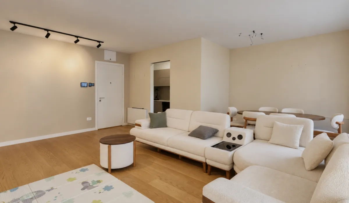 Spacious living room with a sectional sofa and a dining area in the background.