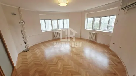 Empty living room with parquet flooring and large windows. - image 2