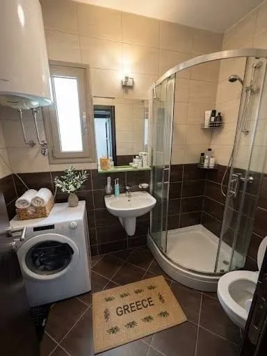 Potpuno opremljeno kupatilo sa tuš kabinom i veš mašinom.