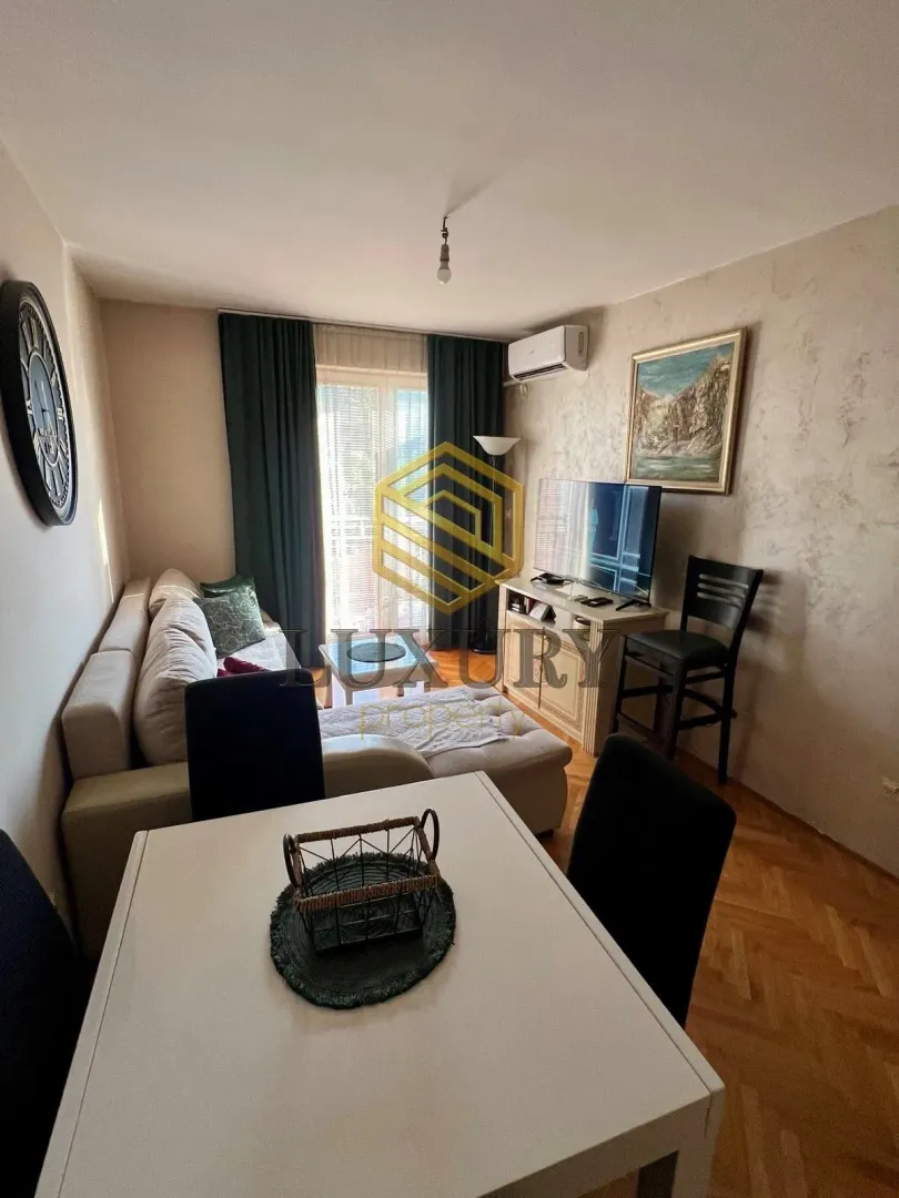 Dnevni boravak sa garniturom, trpezarijskim stolom i izlazom na terasu.