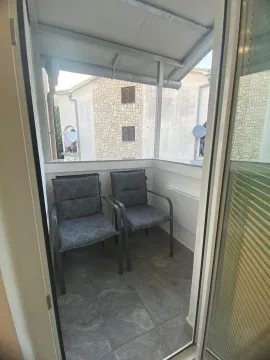 Manji natkriveni balkon sa dvije fotelje, pogled na okolne zgrade. - image 8