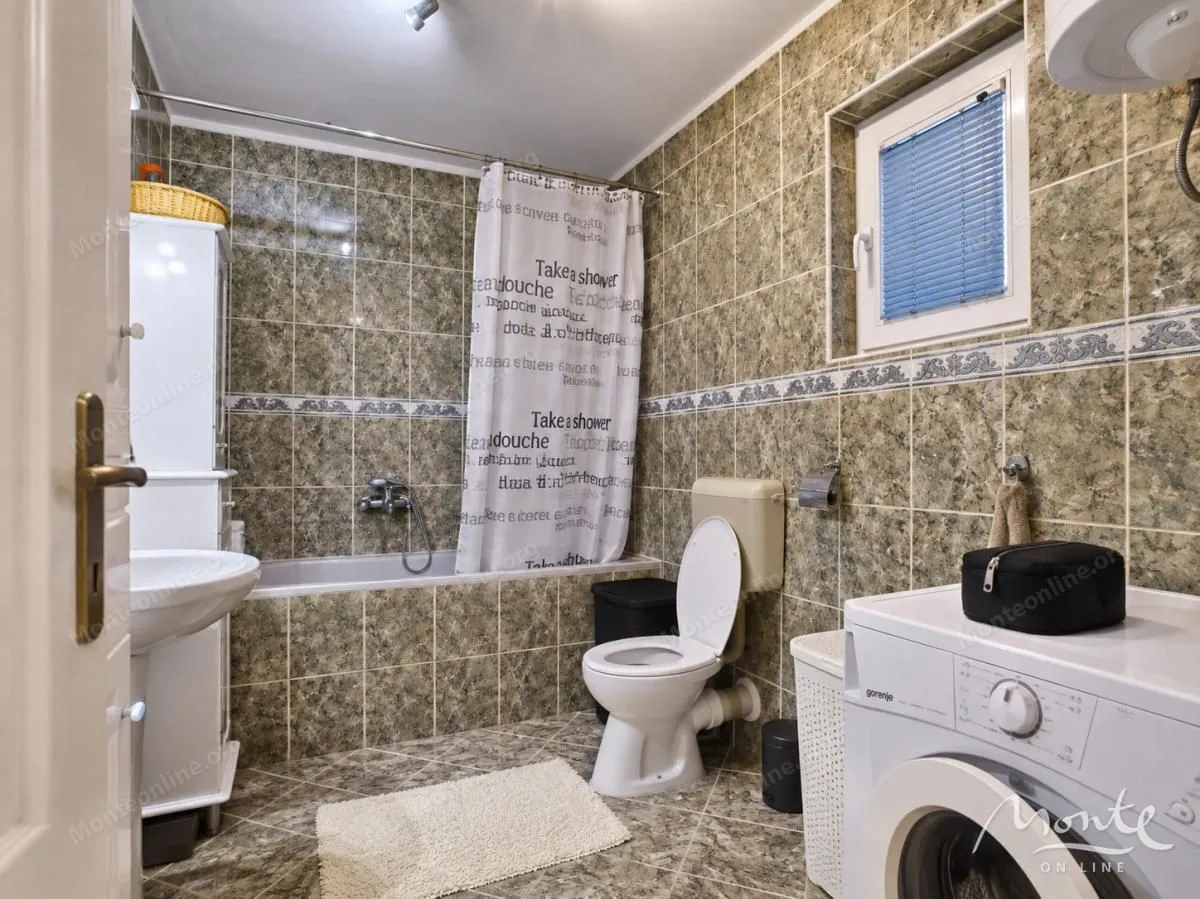 Kupatilo opremljeno kadom, wc šoljom, umivaonikom i veš mašinom.