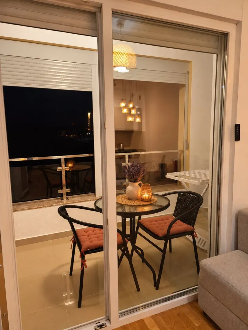 Small covered terrace with a table and two chairs, decorated with details.