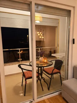 Small covered terrace with a table and two chairs, decorated with details. - image 9