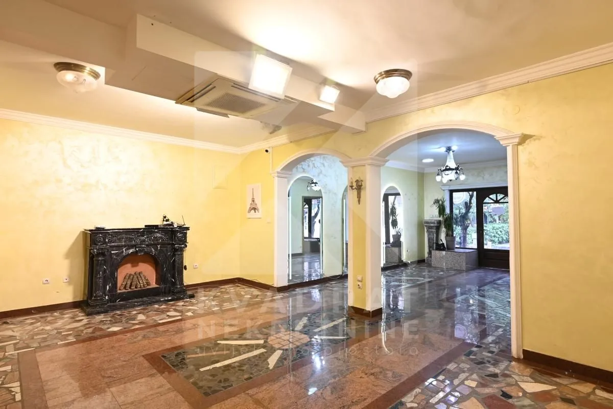 Spacious living room with a fireplace and marble flooring.