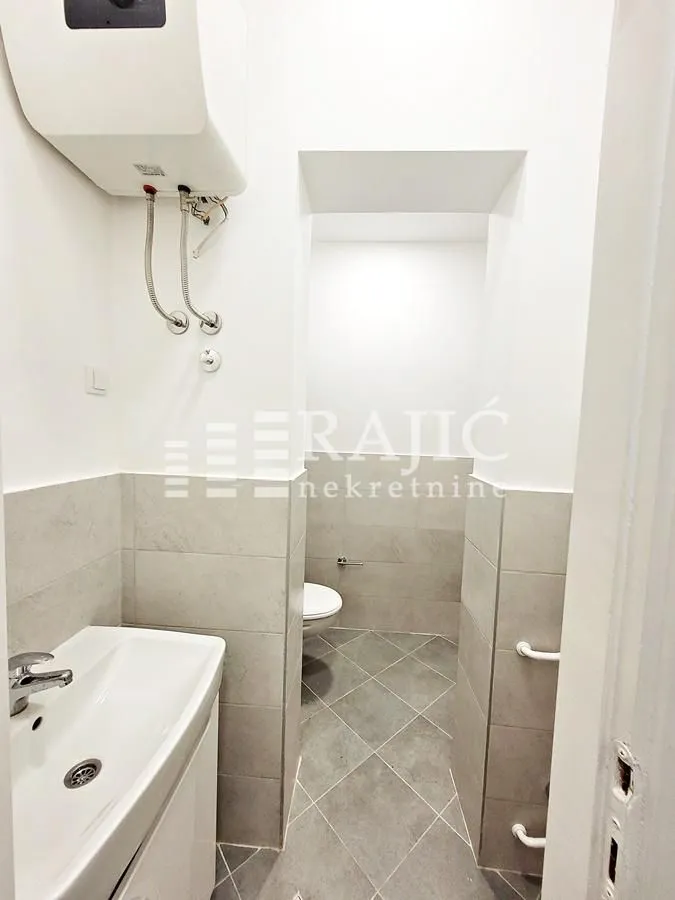 Small bathroom with a sink and water heater.