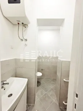 Small bathroom with a sink and water heater. - image 6