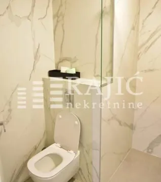 Modernly equipped bathroom with white ceramic tiles and a toilet. - image 8