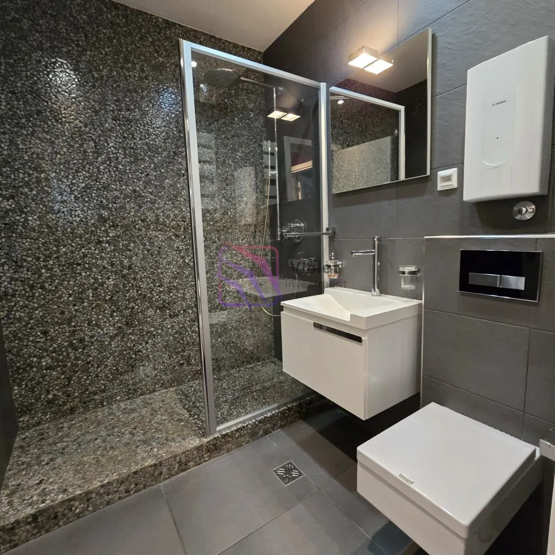 Moderno opremljeno kupatilo sa tuš kabinom, umivaonikom i wc šoljom.