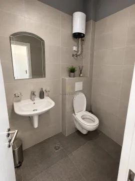 Small bathroom with a washbasin, toilet, and mirror, finished with ceramic tiles. - image 6