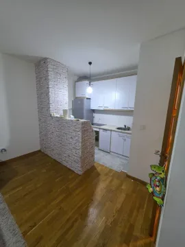 Manja kuhinja sa bijelim elementima i šankom obloženim tapetama koje imitiraju ciglu. - image 6