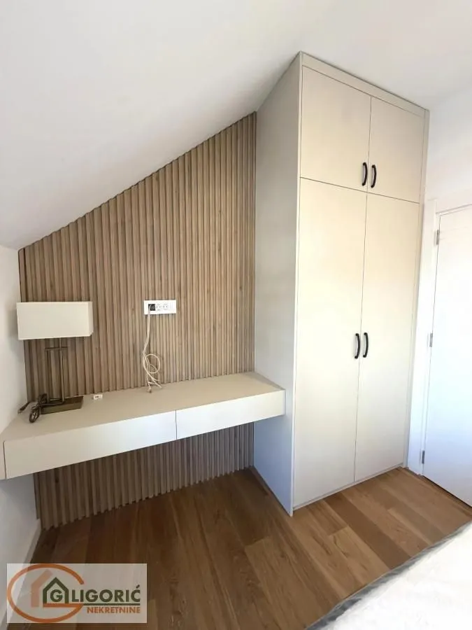 Bedroom with a built-in wardrobe, desk, and wooden wall panels.