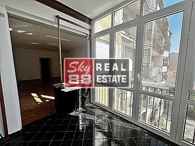 Enclosed terrace with a view of surrounding buildings and access to the interior.