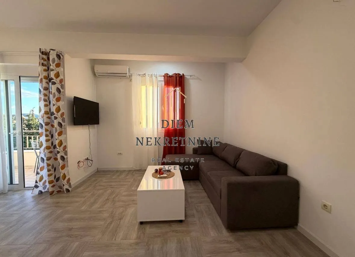 Living room with a sofa, coffee table, and terrace access.