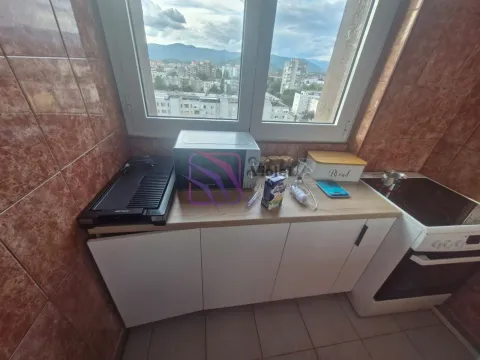 Manja kuhinja sa bijelim elementima, šporetom i pogledom na grad. - image 14