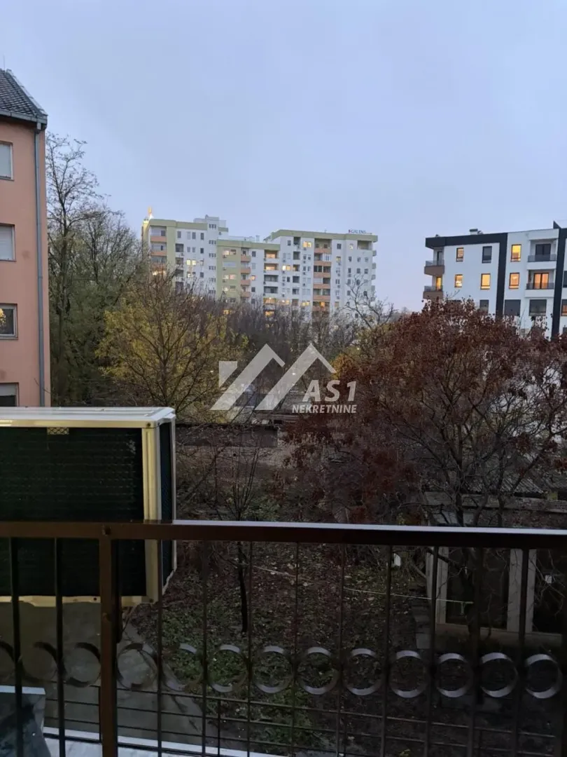 View from the terrace towards surrounding buildings and trees.