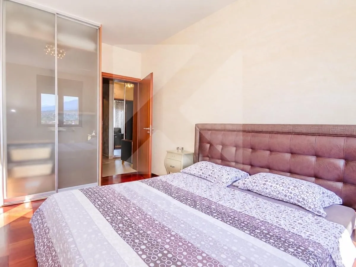 Spacious bedroom with a double bed, wardrobe, and a view.