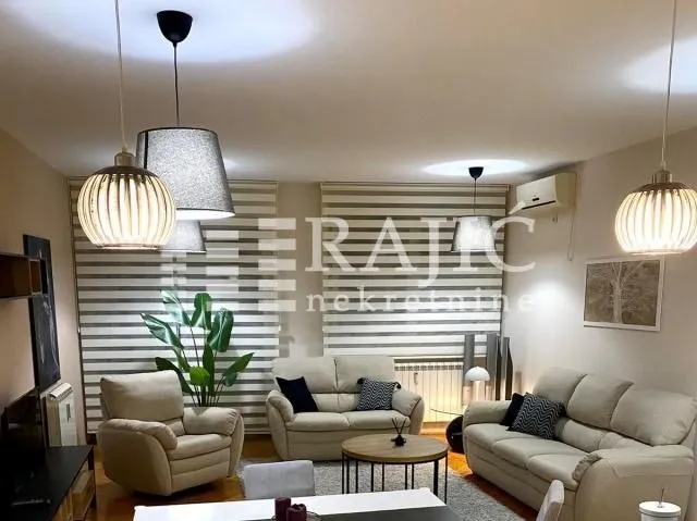 Spacious and furnished living room with sofa set and dining table.