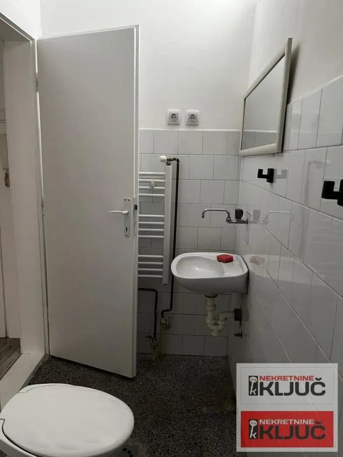 Manje kupatilo sa umivaonikom, ogledalom i wc šoljom.