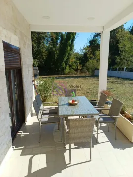 Covered terrace with a dining table and a view of the yard. - image 16