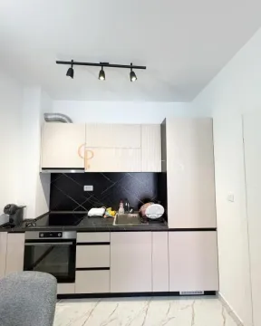 Smaller kitchen with built-in cabinetry and a black countertop. - image 5
