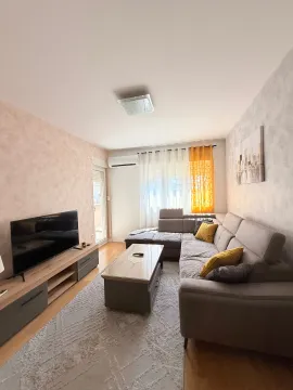 Dnevna soba sa ugaonom garniturom, TV komodom i izlazom na terasu. - image 6